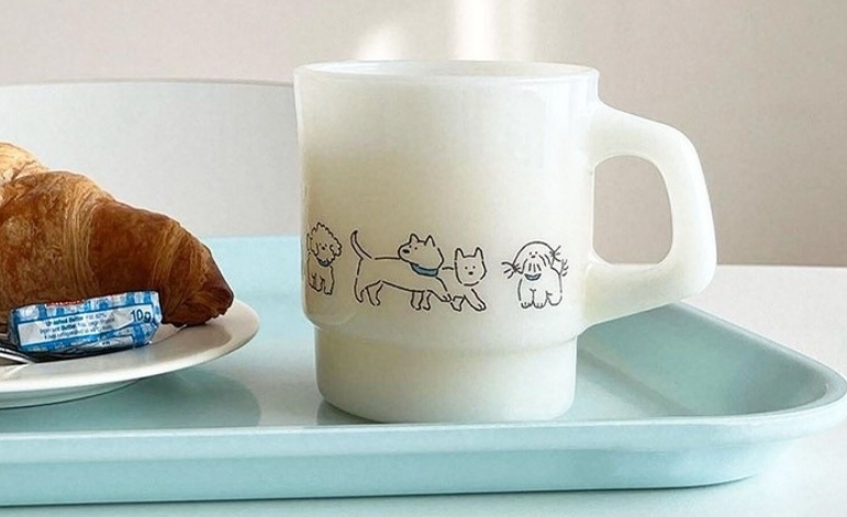 A glass of milk placed next to a milk glass mug, highlighting the visual similarity.