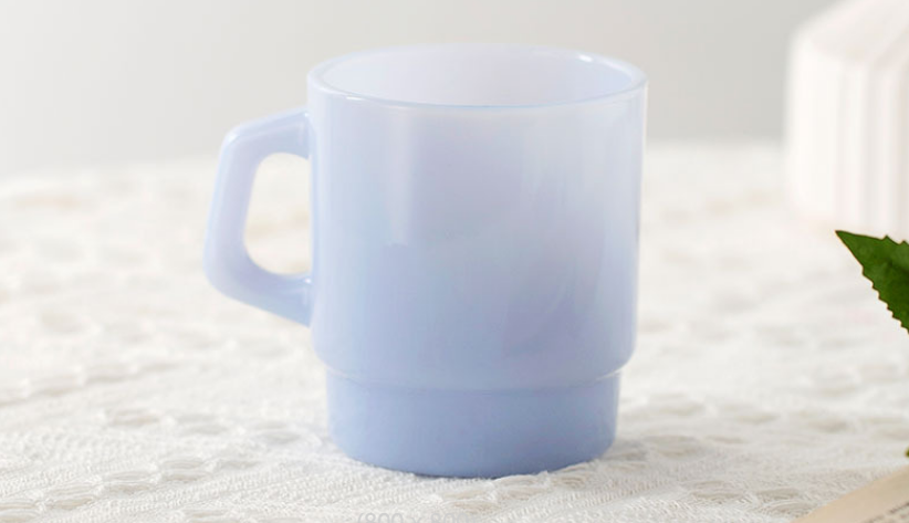 A cross-section of a colored glass mug, showing that the color is consistent throughout the material.