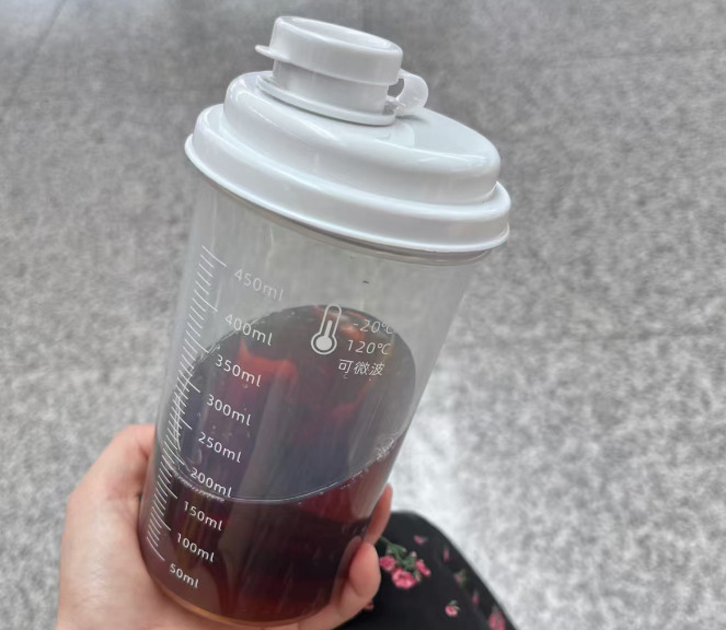 a kitchen thermometer showing a high temperature next to a plastic bottle