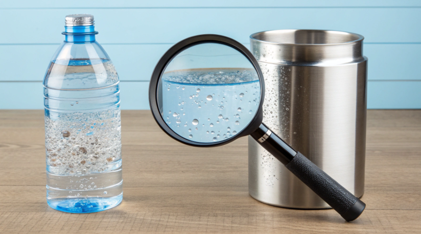 a magnifying glass looking at water from a plastic bottle showing particles vs clean water from steel
