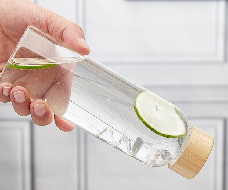a close-up shot of crystal clear water being poured into a transparent glass bottle