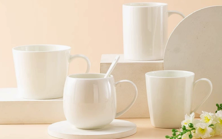 A person holding a thin porcelain mug up to a light source, showing its translucency